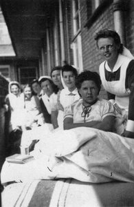 604995 Afbeelding van enkele verpleegkundigen en patiënten bij een onbekend ziekenhuis, vermoedelijk te Utrecht.